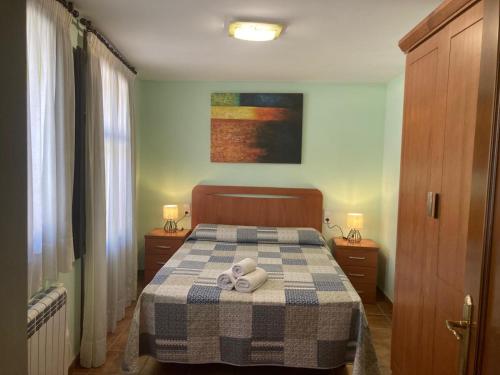 a bedroom with a bed with a checkered blanket at Apartamento O'royo in Alquézar