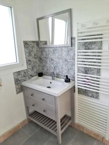 une salle de bain avec un lavabo et un miroir dans l'établissement Maison familiale à proximité du Mont St Michel, à Saint-Méloir-des-Ondes