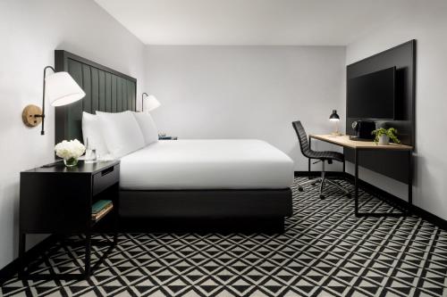 a hotel room with a bed and a desk at The Arcadian in Brookline
