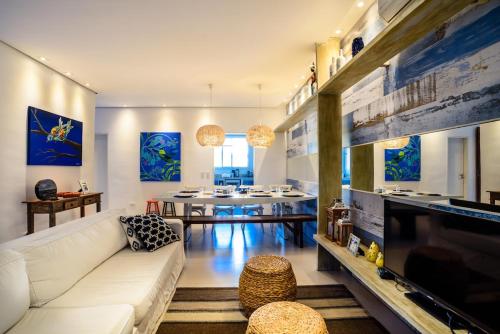 a living room with a white couch and a table at Linda Casa de alto padrão em praia de Juquehy in São Sebastião