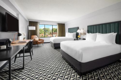 a hotel room with two beds and a desk at The Arcadian in Brookline