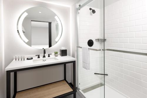a white bathroom with a sink and a mirror at The Arcadian in Brookline