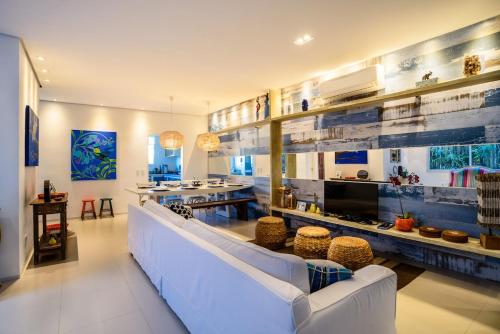 a living room with a white couch and a television at Linda Casa de alto padrão em praia de Juquehy in São Sebastião