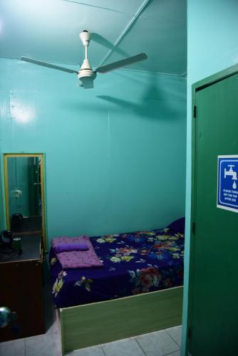 a blue room with a bed and a ceiling fan at Wind Stay in Male City