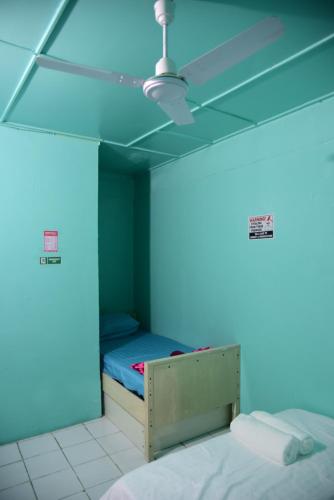 a blue room with a bed and a ceiling fan at Wind Stay in Male City