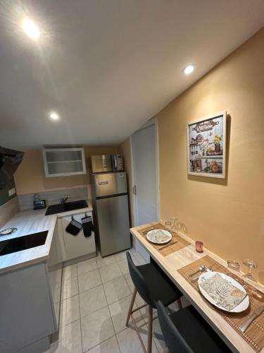 - une petite cuisine avec une table et un comptoir dans l'établissement Le Petit Studio de Merlimont, à Merlimont