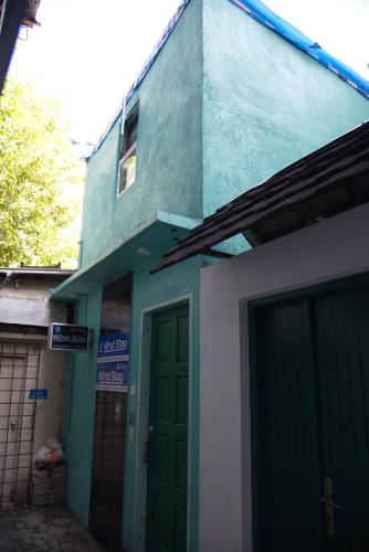 a building with a green door in front of it at Wind Stay in Male City