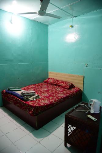 a bedroom with a bed with a red comforter at Wind Stay in Male City