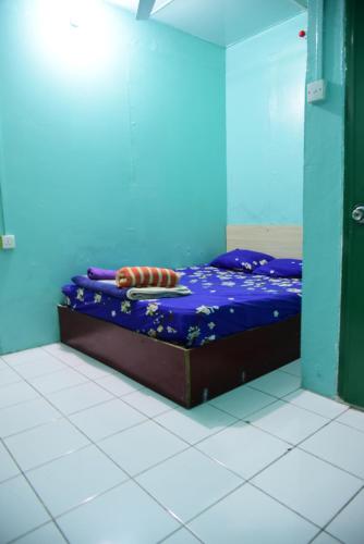 a bed in a room with a blue wall at Wind Stay in Male City