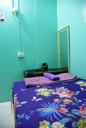 a bed with a purple comforter and a mirror at Wind Stay in Male City