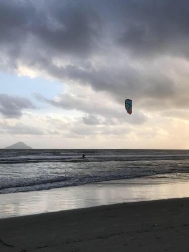 a person is flying a kite on the beach at Linda Casa de alto padrão em praia de Juquehy in São Sebastião