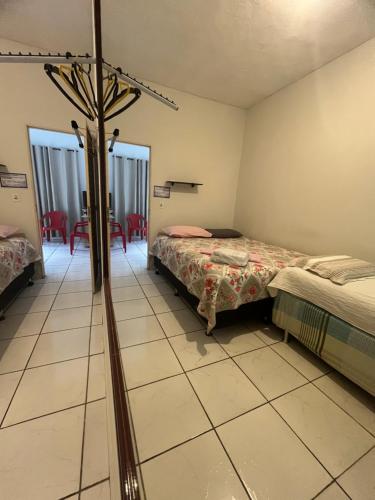 a room with two beds and a room with a bed at Hotel da Gaúcha in Aragarças