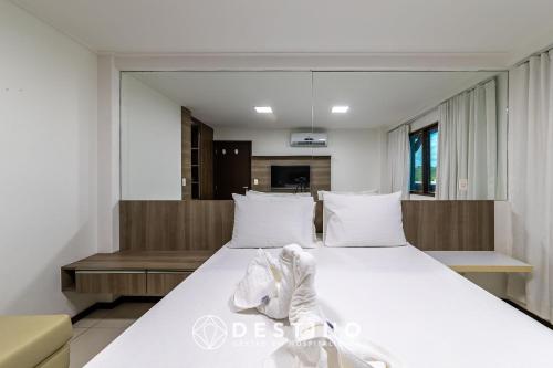 a bedroom with a large bed with white sheets at Barra Bali - Pé na Areia, Vista Mar Incrível - Destino BSM 116 in Barra de São Miguel