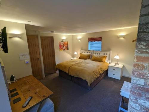 une chambre avec un grand lit et une table dans l'établissement Bandroom Cottage, à Kirkby Stephen