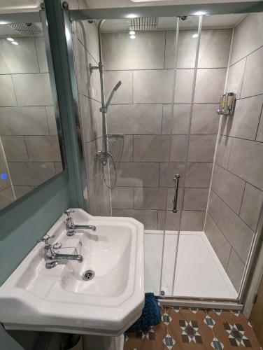 a bathroom with a sink and a shower at Bandroom Cottage in Kirkby Stephen