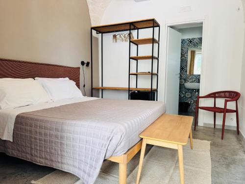 a bedroom with a bed and a ladder and a table at Tenuta Amostuni-Country House in Ostuni