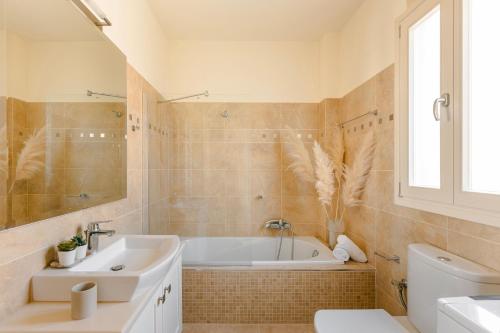 EFLにあるAlma Luxury Residences- Eos apartment 3の浴槽、洗面台、トイレを備えたバスルーム