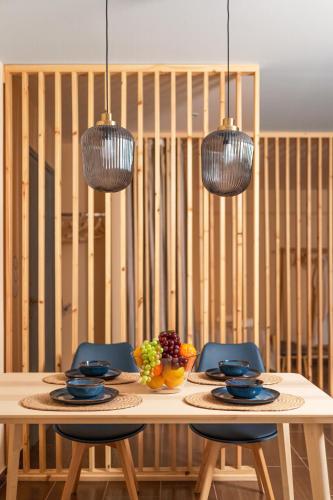 a dining room table with two chairs and two lights at Cozy studio in the centre in Sitia