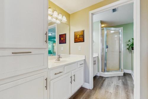 Un baño blanco con lavabo y ducha. en Waters Edge Condominiums, en Fort Walton Beach