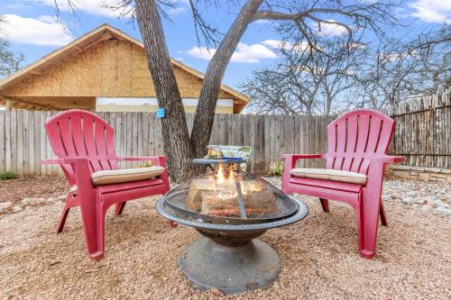 two pink chairs and a fire hydrant in a yard at Serendipity in Fredericksburg