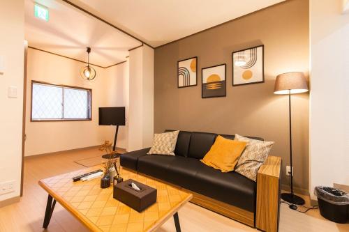a living room with a black couch and a table at 楽宿 Itabashi 011T in Tokyo