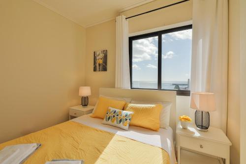 a bedroom with a bed and a large window at House at the Sea (city historial center with sea view) in Ponta Delgada