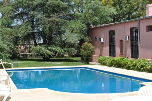 a swimming pool in front of a pink house at Hotel El Molino in Venado Tuerto