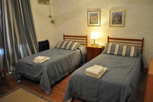 two beds in a hotel room with towels on them at Hotel El Molino in Venado Tuerto
