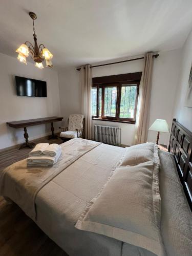 a bedroom with a large bed and a table at Gestiona2R- Casa con finca para desconectar cerca de la playa in Llanes