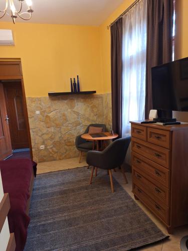 a bedroom with a tv and a desk with a chair at Arany Elafánt Szálláshely in Esztergom