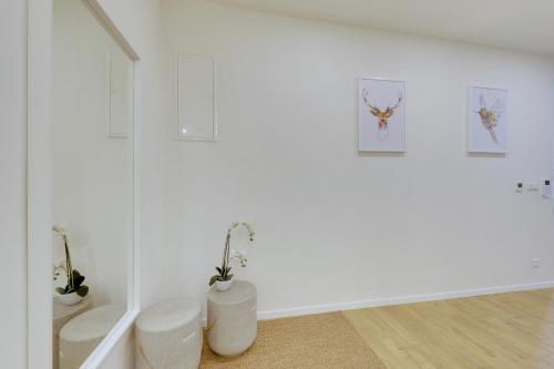 a white room with two stools and two pictures on the wall at Shon apartment Old Town in Bratislava