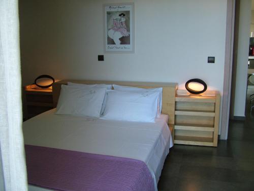 a bedroom with a bed and two lamps on a table at Sugar and Almond in Agios Stefanos