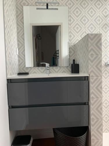 a bathroom with a sink and a mirror at Maison bretonne de charme in Plumergat