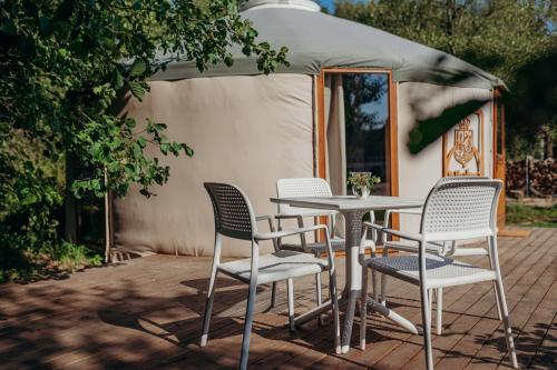 a table and chairs on a patio with a tent at Zatoka Bielika Glamping in Sielsko