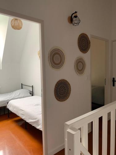 a room with two beds and plates on the wall at Maison bretonne de charme in Plumergat
