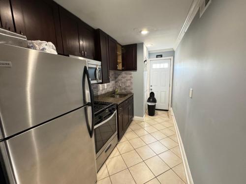 a kitchen with a stainless steel refrigerator and a tile floor at NICE 2-Bedroom Apartment in DC in Washington, D.C.