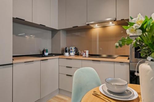 a kitchen with white cabinets and a table with a bowl on it at The Address Bucharest in Bucharest