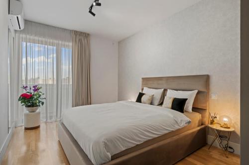 a bedroom with a large bed and a window at The Address Bucharest in Bucharest