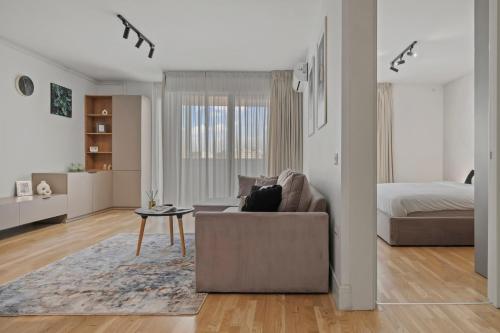 a living room with a couch and a bed at The Address Bucharest in Bucharest