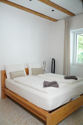 a large white bed in a room with a window at Gardar in Bolzano