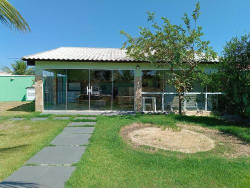 a house with glass doors and a yard at Aconchego in São Pedro da Aldeia