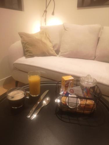 a coffee table with a basket of food and a glass of orange juice at appartement cosy sur Condrieu in Condrieu