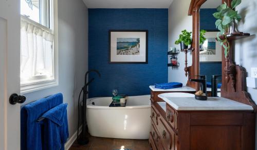 a blue bathroom with a tub and a sink at Glenn Meadow Bed and Breakfast in South Haven