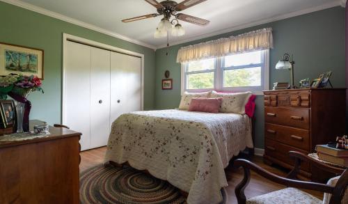 a bedroom with a bed and a dresser and a window at Glenn Meadow Bed and Breakfast in South Haven