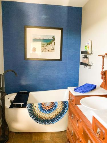a bathroom with a bath tub and a sink at Glenn Meadow Bed and Breakfast in South Haven