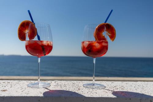 tres copas de vino sentadas en una mesa cerca del océano en Gallipoli Il mare in una stanza, en Lido Conchiglia