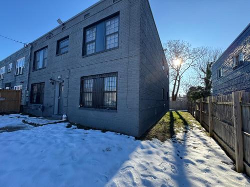 a brick house in the snow in front of a fence at NICE 2-Bedroom Apartment in DC in Washington, D.C.