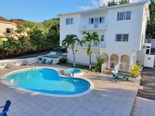 a swimming pool in front of a house at Turquoise Sea Villa in Montego Bay