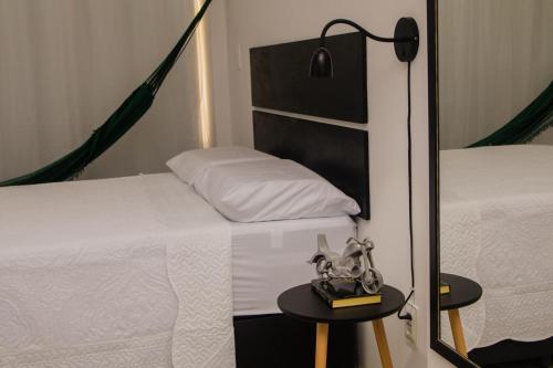 a bedroom with two beds and a table with a lamp at Flat vista para o mar in Cabedelo