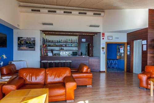 a waiting room with leather couches and a bar at Platjador in Sitges